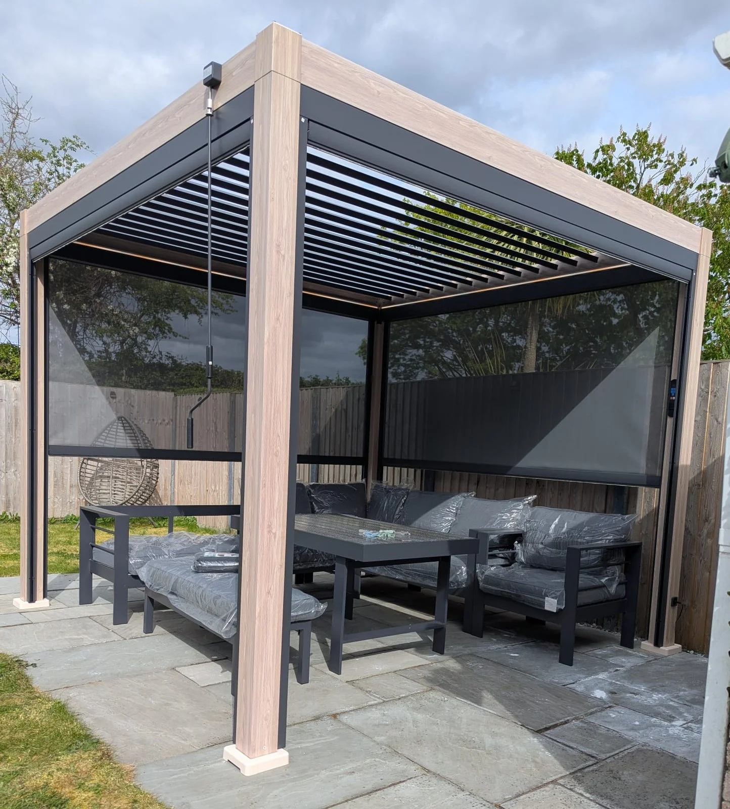 LuxShade™ 3×3m Aluminium Pergola – LEDs, Double-Layer Louvres & 3 Windscreens - Oak Effect - Image 3